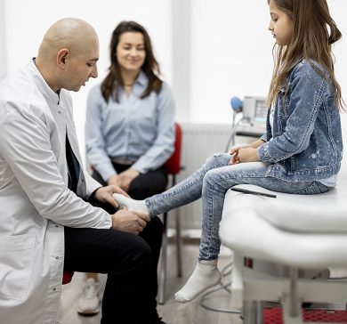 Pediatric orthopedist talking with a little girl and her mom